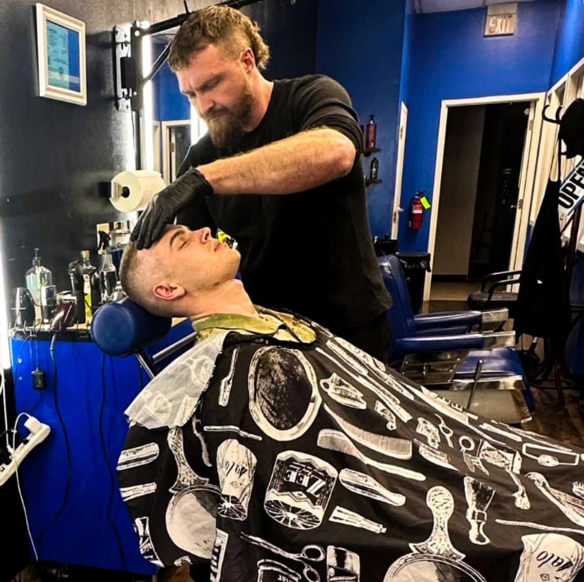 Zach Blackburn giving a client a haircut at the barbershop